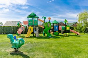 a playground with a bunch of slides in a field at Domki Morena - Rodzinne Domki Blisko Plaży in Karwia