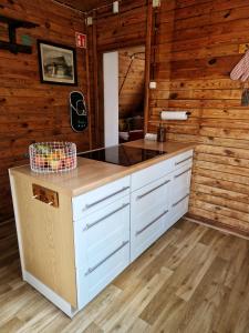 a kitchen with white cabinets and a counter top at Leśna Chatka in Wola Polska +28 photos