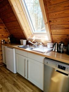 a kitchen with a sink and a window at Leśna Chatka in Wola Polska
