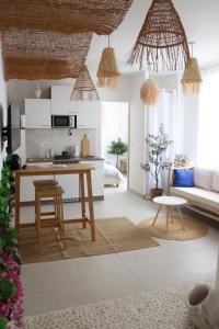 a kitchen and living room with a table and chairs at Loveroom Mykonos avec balnéothérapie in Toulon