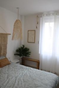 a bedroom with a bed and a window and a plant at Loveroom Mykonos avec balnéothérapie in Toulon +31 photos