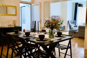 a dining room table with chairs and a vase of flowers at Luxury Apartment in Old Town in Prague