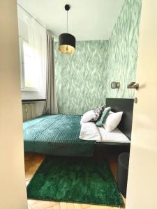 a bedroom with a bed with green sheets and a window at Luxury Apartment in Old Town in Prague