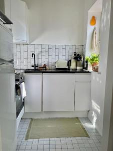 a kitchen with white cabinets and a sink at Bright and modern apartment in Grand Canal Docks in Dublin