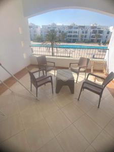 a balcony with chairs and a table and a pool at Palemera in Ain Sokhna