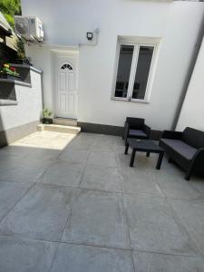 a patio with two couches and a white building at Maison Saint Pierre in Dinant