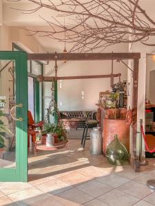 a living room with a green door and some plants at Ennesima Osteria con Alloggio - Bike Hotel in Toscolano Maderno