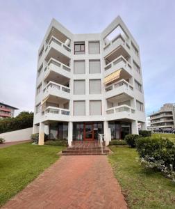 a large white apartment building with a lawn in front at Frente al mar hermoso in Punta del Este