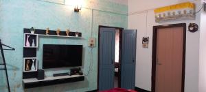 uma sala de estar com televisão e uma parede azul em The Acoustics em Guwahati