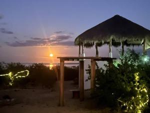 un cenador en la playa con la puesta de sol en el fondo en Casa Kukuaa, en La Ventana