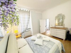 a bedroom with a bed and a vase with purple flowers at CINQUE TERRE MONEGLIA in Moneglia