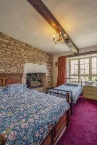 una camera con due letti e un muro di pietra di Medieval Manor a Caldicot