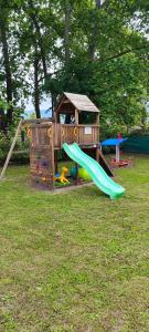 a playground with a slide and a play house at My Rooms in Leptokaria