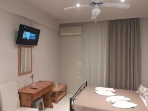 ケリオンにあるStudios Annaのベッド2台と壁掛けテレビが備わる客室です。