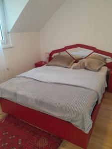 een bed met twee kussens in een slaapkamer bij 2 chambres adjacentes avec lit Queen size in Commugny