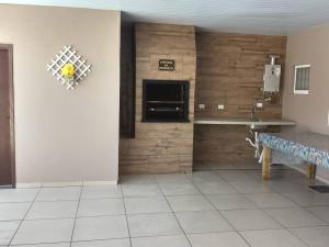 a living room with a table and a fireplace at Casa com piscina e ar condicionado condicionado in Matinhos