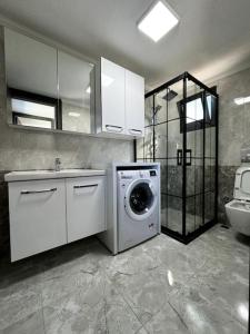 a bathroom with a washing machine and a sink at Triplex Villa with Pool in a Secure Site in Izmir