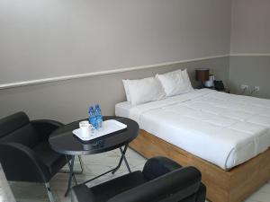 FourPoints Lodge في ليلونغوي: غرفة فندقية بسرير وطاولة وكراسي