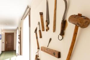 a bunch of old tools hanging on a wall at Locanda Del Mulino in Maranello