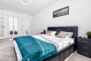 ein Schlafzimmer mit einem großen Bett mit einer blauen Decke in der Unterkunft Набережная, небоскребы, кофейня, фитнес, стильно и недорого, ЖК 7Я in Astana