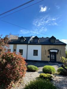 uma grande casa branca com um telhado preto em Jager Guesthouse em Sopron