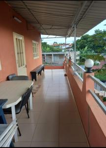 un balcone di un edificio con tavolo e sedie di VIP Guest House Campo de Milho a São Tomé