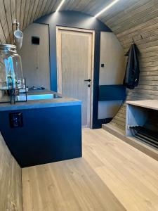 uma cozinha com um balcão azul e um lavatório em Dreamy Barrel em Ljotegard