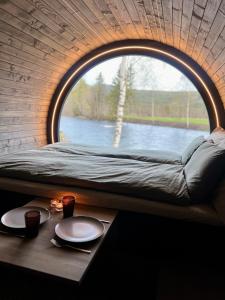 Cette chambre comprend un lit et une table avec une fenêtre. dans l'établissement Dreamy Barrel, à Ljotegard