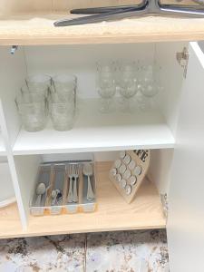 a kitchen shelf with glasses and utensils at House Valencia in Cuart de Poblet