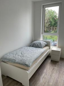 a white bed in a room with a window at boll appartments GmbH Taucha in Taucha