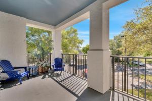 a balcony with two blue chairs and a table at Luxury 3bd, 2bath, universal studios in Orlando