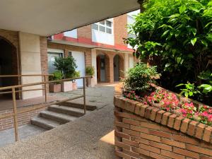 Un edificio con escaleras y flores en una pared de ladrillos. en Puerta 10, en El Astillero