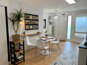 Una cocina y un comedor con mesa y sillas. en Puerta 10, en El Astillero