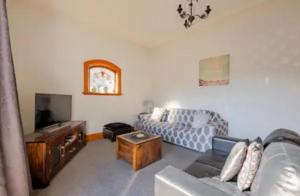 a living room with a couch and a tv at St Clair Holiday House in Dunedin