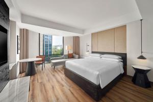 1 dormitorio con 1 cama blanca grande y 1 sofá en Sheraton Hanoi West, en Hanói