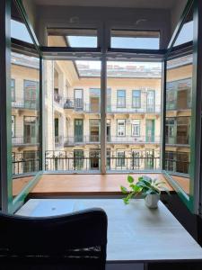 a room with a table and a large window at Central Charm in Budapest's Bustling 7th District in Budapest