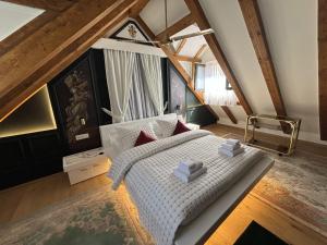 sypialnia z białym łóżkiem na poddaszu w obiekcie KAŽIN supreme w Kotorze