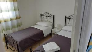 two beds in a small room with a mirror at Lovely House risveglio fronte mare in Marina di Pescoluse