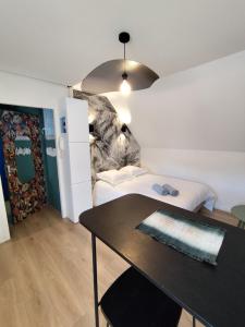 a small room with a bed and a table at LE ARA - Gare - centre ville - By Nid'Ouest in Quimper +4 photos