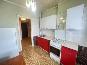 uma cozinha com armários vermelhos e electrodomésticos brancos em MAGIC STUDIO FRANCE em Saint-Louis