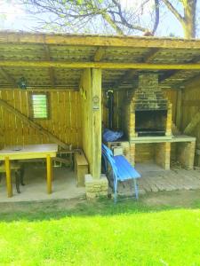 a picnic table and a bench in front of a fireplace at La Casiru guesthouse in Straja