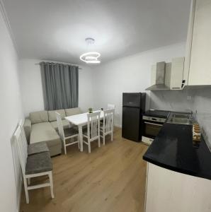 eine Küche und ein Wohnzimmer mit einem Sofa und einem Tisch in der Unterkunft Vila Ademi Ksamil in Ksamil