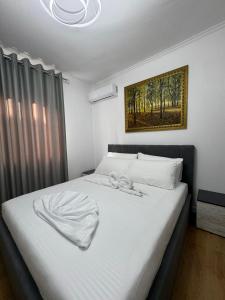 ein Schlafzimmer mit einem großen Bett mit weißer Bettwäsche in der Unterkunft Vila Ademi Ksamil in Ksamil