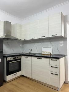 eine Küche mit weißen Schränken und einem schwarzen Gerät in der Unterkunft Vila Ademi Ksamil in Ksamil
