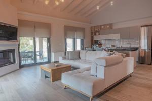 a living room with a white couch and a table at Carpe Diem Moursia House in Liapades