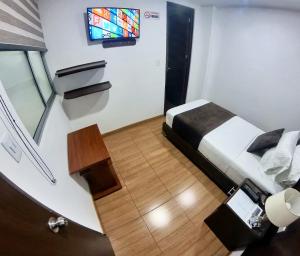 a small room with a bed and a tv at Hotel Victoria Real Tunja in Tunja