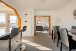 une salle à manger avec des chaises et une table à manger dans l'établissement St Clair Holiday House, à Dunedin