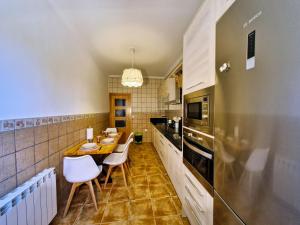 a kitchen with a wooden table and white chairs at Casa de la tía Irene in Briñas