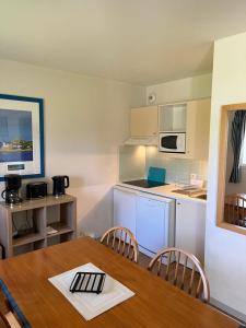 eine Küche mit einem Holztisch und einem Esszimmer in der Unterkunft Appartement T3 équipé in Carantec