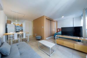 een woonkamer met een bank en een flatscreen-tv bij Loft en Güemes in Cordoba